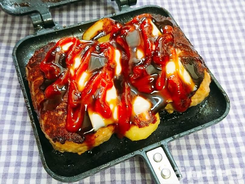 ホットサンドメーカーで焼いたハンバーグとじゃがいもにとろけるチーズをのせてケチャップと中濃ソースをかける