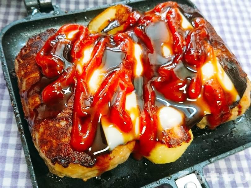 ホットサンドメーカーで焼いたハンバーグとじゃがいもにとろけるチーズをのせてケチャップと中濃ソースをかける