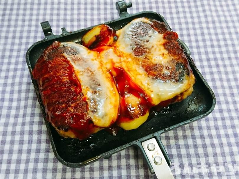 ホットサンドメーカーで焼いたハンバーグとじゃがいもにとろけるチーズをのせてケチャップと中濃ソースをかける