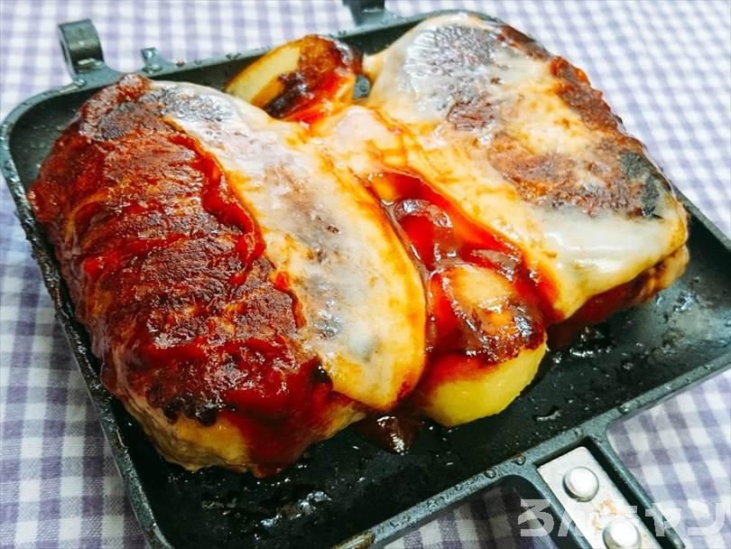 ホットサンドメーカーで焼いたハンバーグとじゃがいもにとろけるチーズをのせてケチャップと中濃ソースをかける