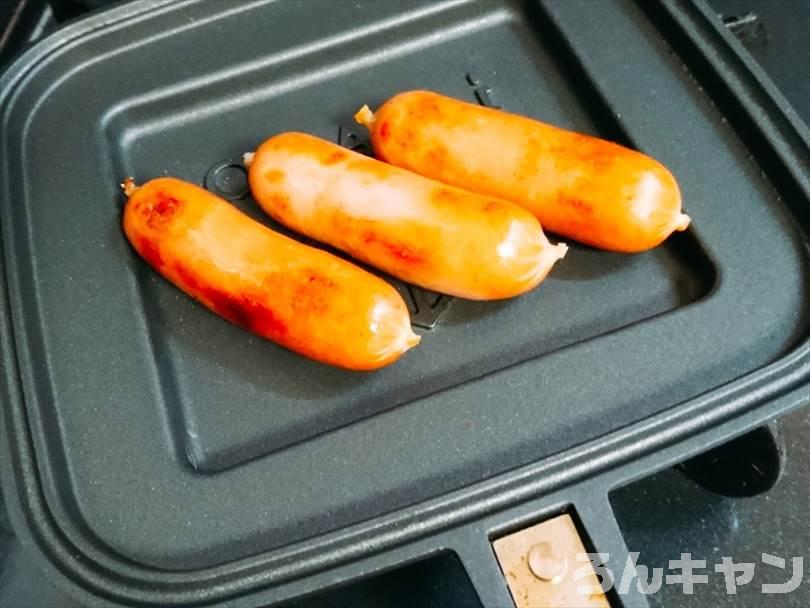 ホットサンドメーカーでソーセージを焼いている