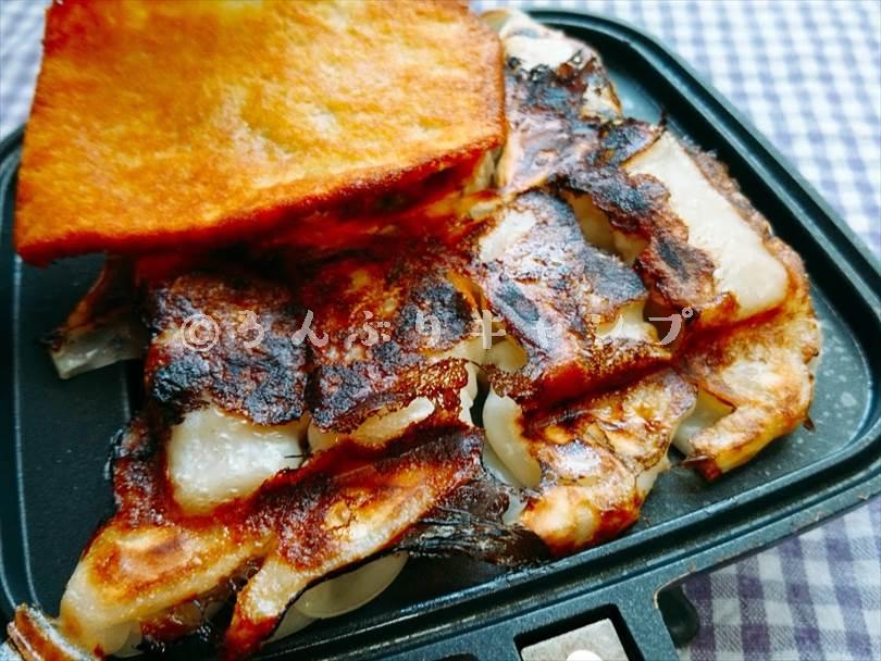ホットサンドメーカーで焼いた後の餃子にカリカリチーズをトッピングしたもの