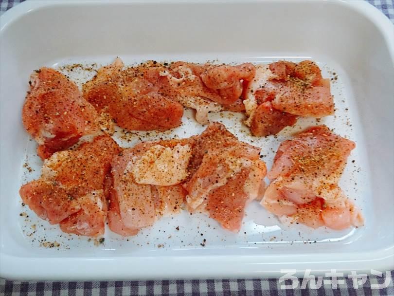 バットに入れた唐揚げ用の鶏肉に下味のマキシマムをかける