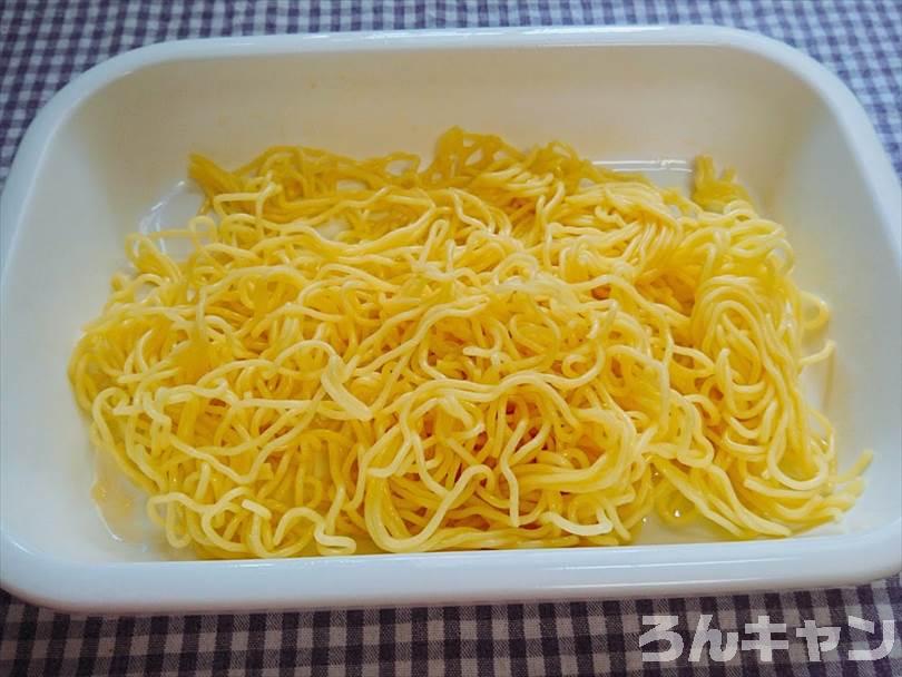 バットに焼きそばの麺を入れてごま油であえる