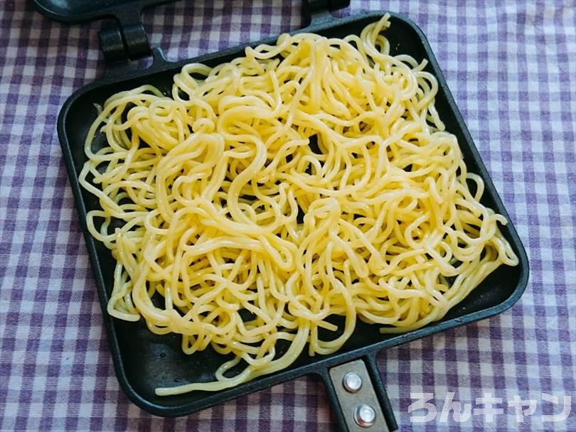 ホットサンドメーカーに焼きそばの麺をのせる