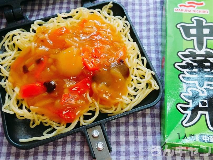 ホットサンドメーカーにのせた焼きそばの麺の上に中華丼の素をのせる
