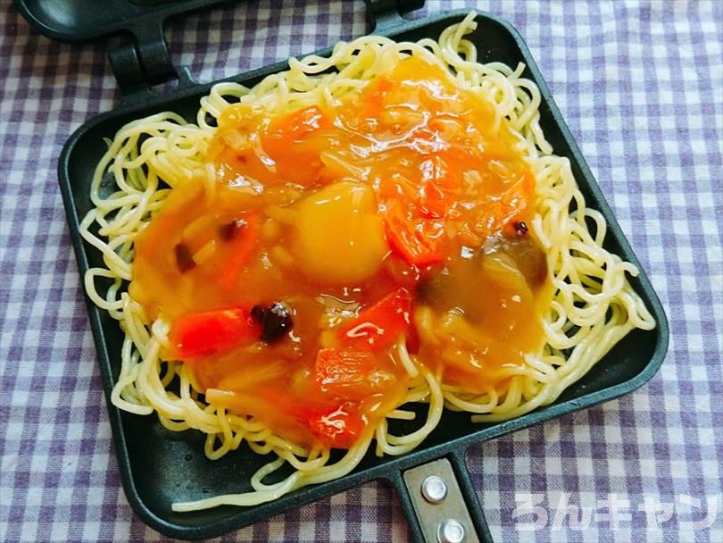 ホットサンドメーカーにのせた焼きそばの麺の上に中華丼の素をのせる